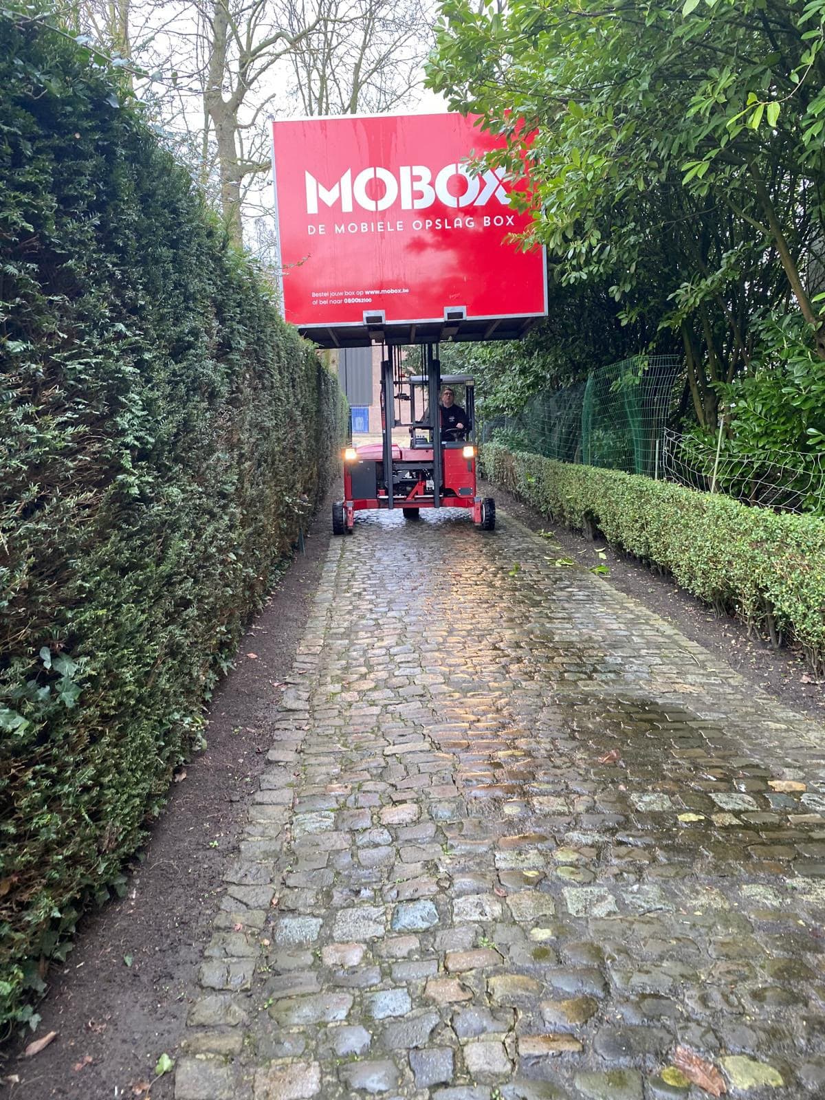 De heftruck brengt een MOBOX-box over een smalle kasseiweg